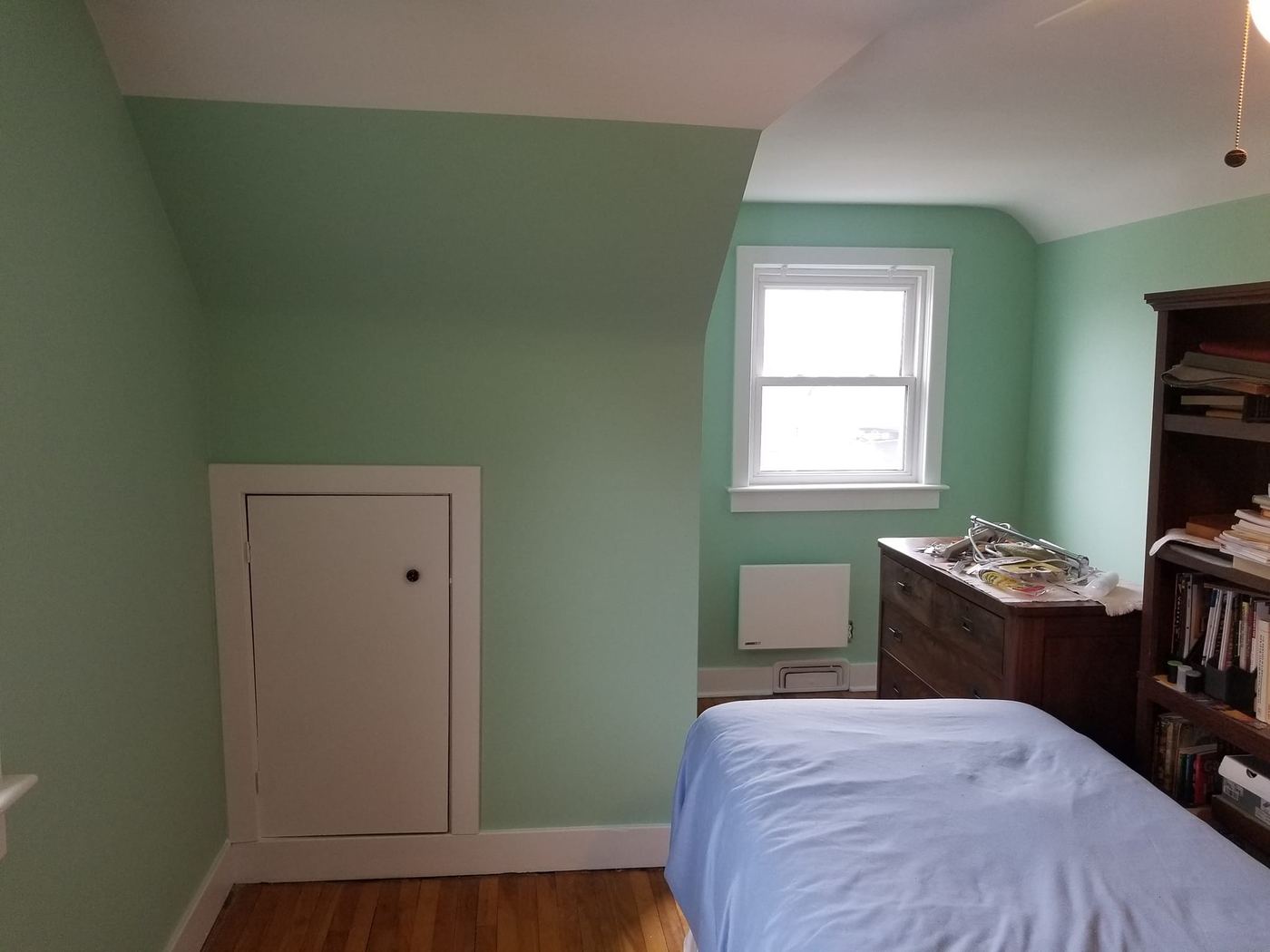 Bedroom painted in sage green with white trim